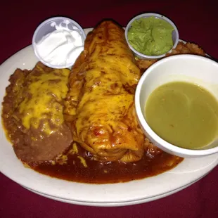 Chimichanga Plate Enchilada Style with Beans and a Side of Green Chili Sauce