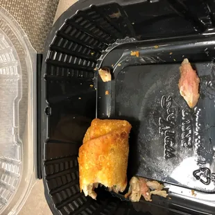 a half eaten sandwich in a plastic container