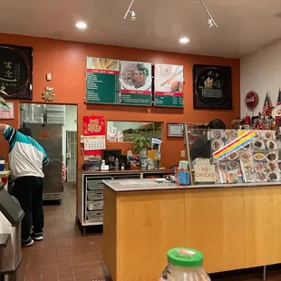a restaurant counter with a person standing at the counter