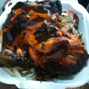 Jerk chicken over cabbage with jerk sauce and hot pepper sauce