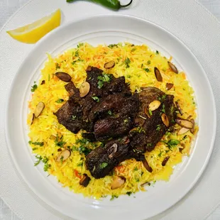 a plate of rice with meat and vegetables