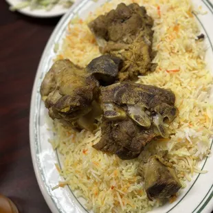 a plate of rice with meat and vegetables