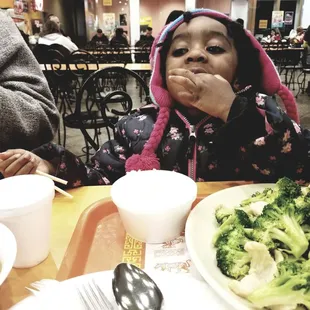 Has chopsticks, but uses hands to eat her steamed rice and broccoli. Effective.  The portions are family style which is good to know!