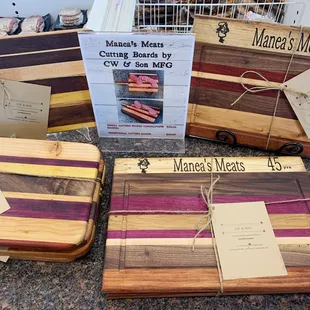 Locally made cutting boards with Manea's Meats wood burned into the board.