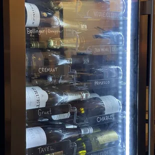 Fridge filled with a large selection of wines and champagnes