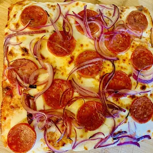 pepperoni and onions on a pizza