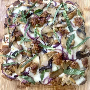 a pizza with mushrooms, onions, and meat