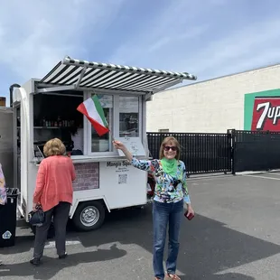 a woman standing in front of a food truck