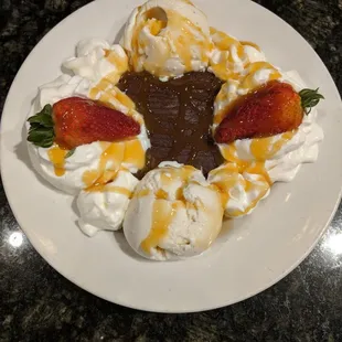 Brownie w/ vanilla bean ice cream, whip cream and strawberries. You can pick raspberry, caramel or chocolate sauce on top. Delish!