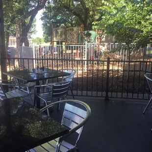 Patio with fans and view of fenced in playground