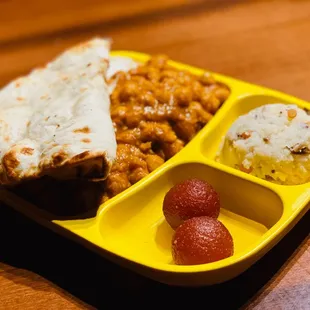 a plate of food with a burrito, rice, and strawberries