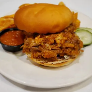 Barbeque Pulled Pork Sandwich with orange-pineapple barbecue sauce, shredded cabbage on house-made bun.