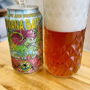 a glass of beer next to a can