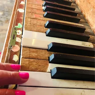 a person's hand playing the piano