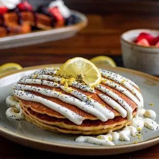 a stack of pancakes with a lemon drizzle on top