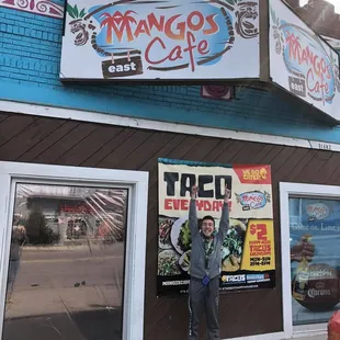 a man standing in front of a restaurant
