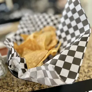 a basket of chips and a salt shaker