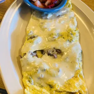 an omelet and a bowl of strawberries