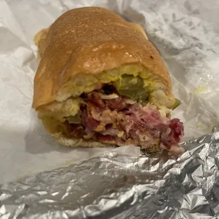 a half eaten sandwich on tin foil