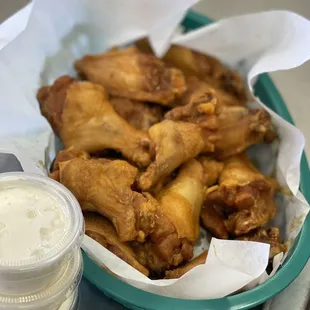 a basket of chicken wings and a cup of beer