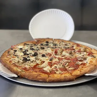 a pizza with pepperoni, olives, and cheese