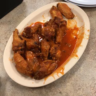 a plate of chicken wings covered in sauce