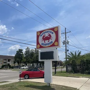 a red car parked in front of the sign