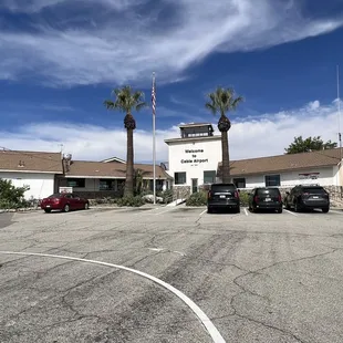 a parking lot with cars and palm trees
