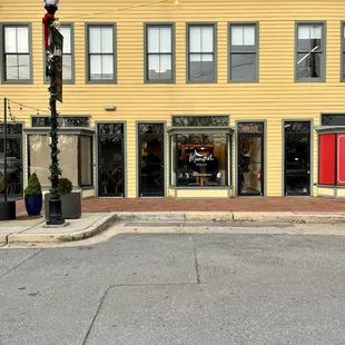a yellow building with a red door
