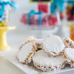a pile of powdered sugar cookies on a plate