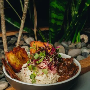 a bowl of rice with meat and vegetables