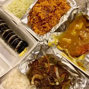 a tray of food with rice, meat, and vegetables
