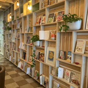 Wooden box wall with various plant based books and cookbooks.