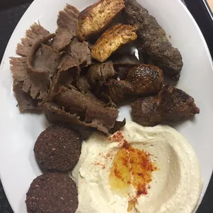 Mixed grill with sides of falafel and hummus.