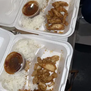 two trays of chicken wings and rice