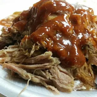 a pulled pork sandwich on a paper plate