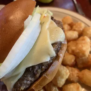 a hand holding a cheeseburger