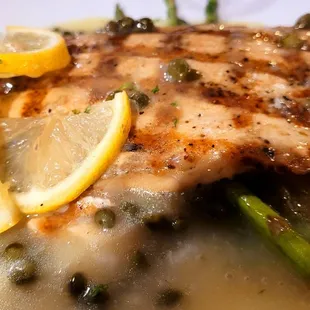 a piece of chicken with asparagus