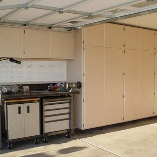 a garage with cabinets and a work bench
