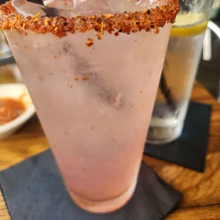 a pink drink with a flower garnish