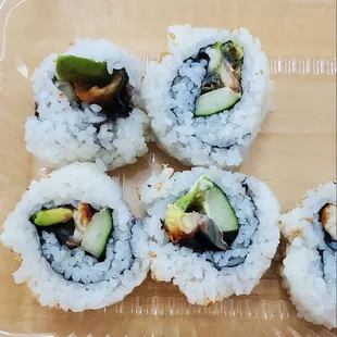 four sushi rolls in a plastic container