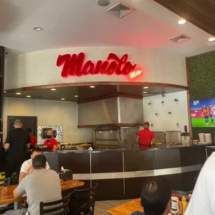 the inside of a restaurant with people sitting at tables