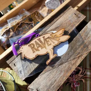 a wooden sign with a raven on it