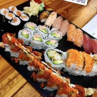a variety of sushi on a black plate