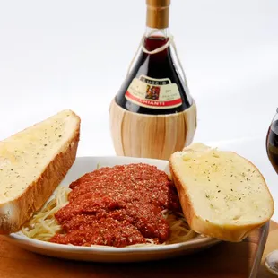 Spaghetti with meat sauce complemented with garlic toast.