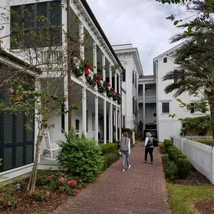 two people walking down a brick walkway