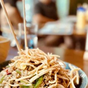 a bowl of noodles with chopsticks