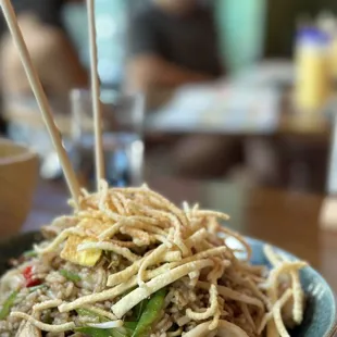 a bowl of noodles with chopsticks