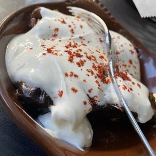 a chocolate dessert with cream and red pepper sprinkles