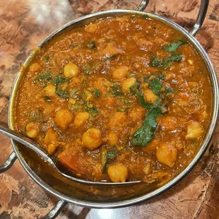 a bowl of curry with a spoon in it